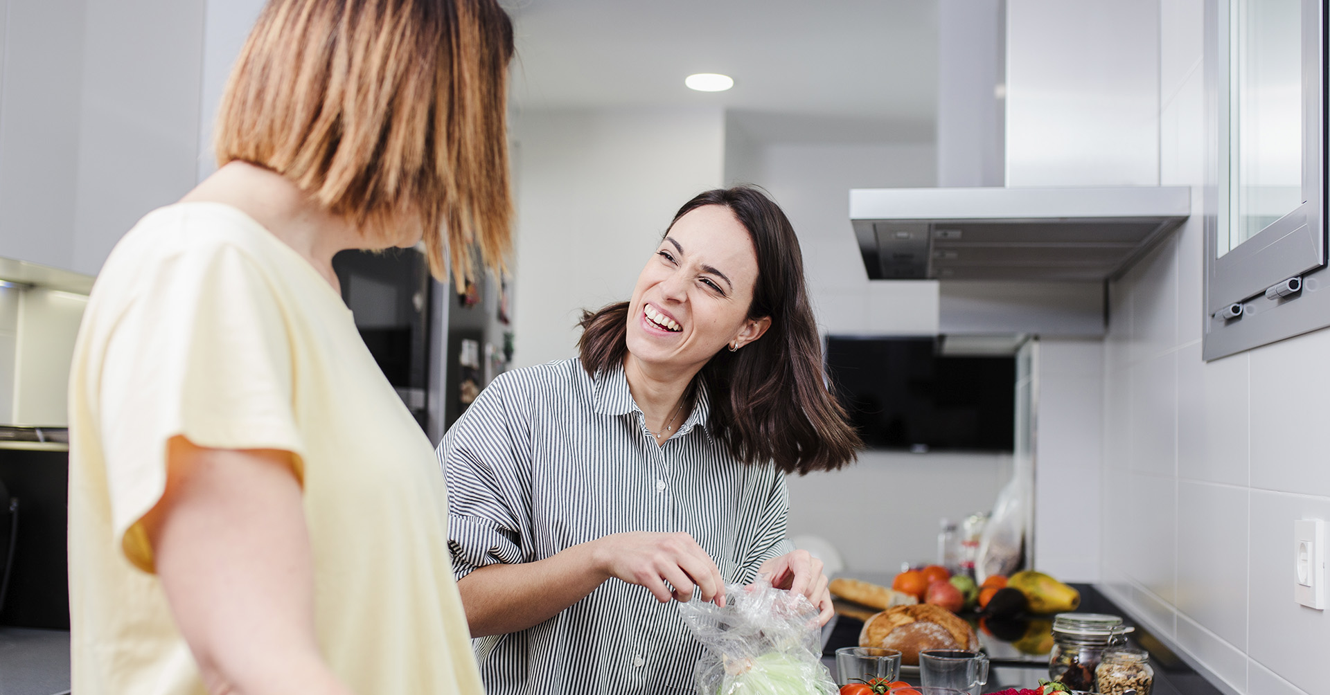 Woman receiving support at home - two women prepare a healthy lunch together in the kitchen